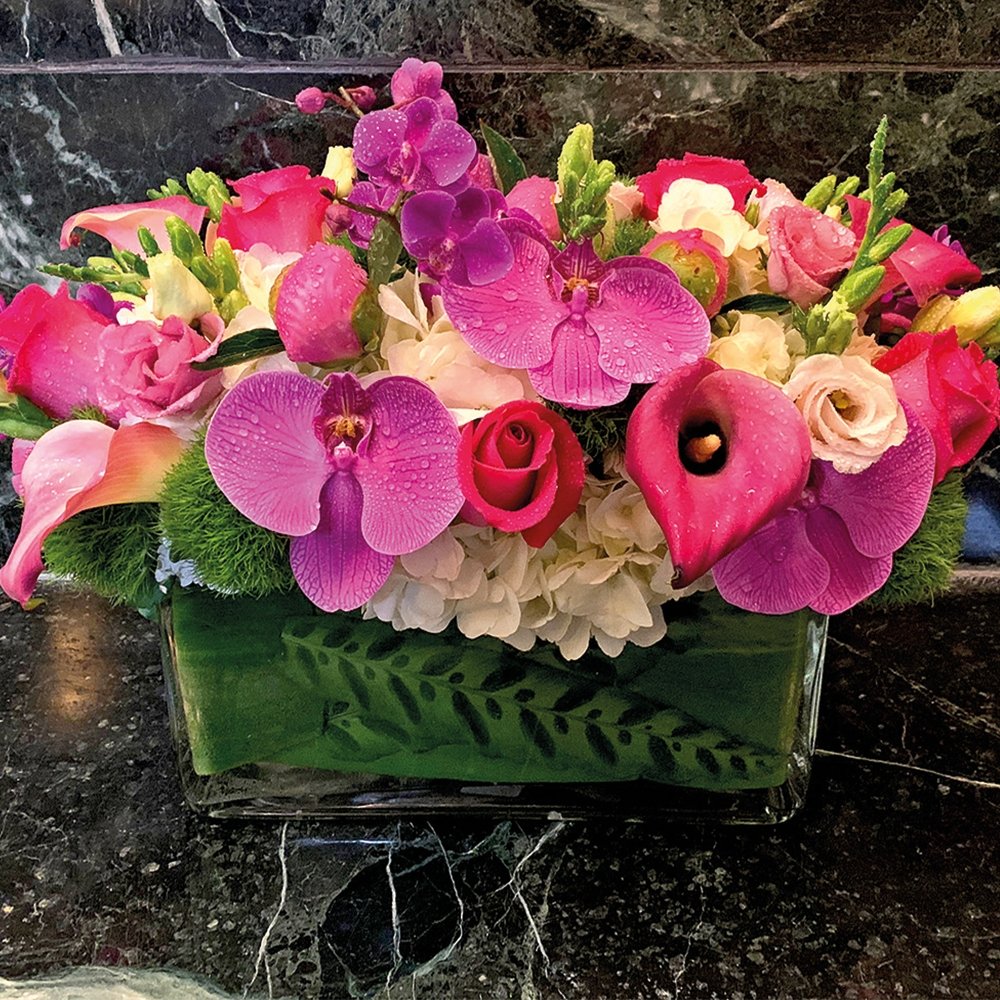 Cheer floral centerpiece arrangement by Heather Floral, featuring pink and white roses, orchids, and lilies