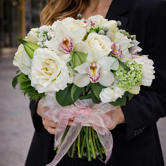 Experience the elegance of the White Fantasy Bouquet by Heather Floral, shown in a lifestyle setting with full focus on the bouquet’s natural white roses and orchids. Designed for those who appreciate classic beauty and craftsmanship. Order today with free same-day flower delivery in Manhattan, New York City.

Model holding the White Fantasy Bouquet by Heather Floral with free same-day delivery in Manhattan NYC