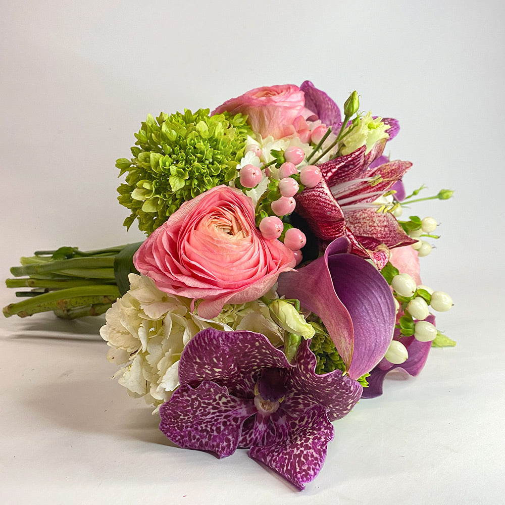 Pink, purple, and white flower bouquet featuring Vanda orchids, Calla lilies, amaryllis, ranunculus, and white hydrangea.