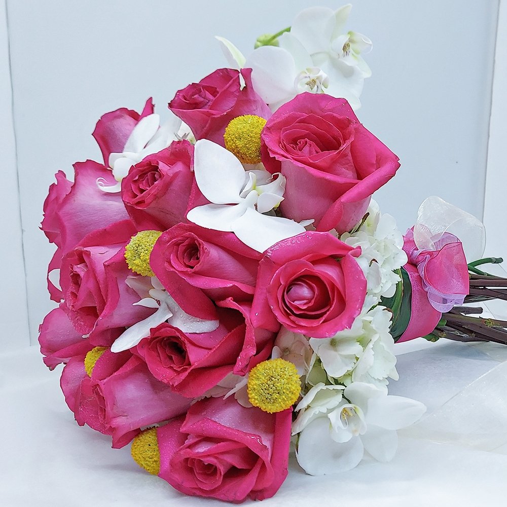 Brightly colored mixed flower bouquet by Heather Floral, featuring white Phalaenopsis orchids and pink roses
