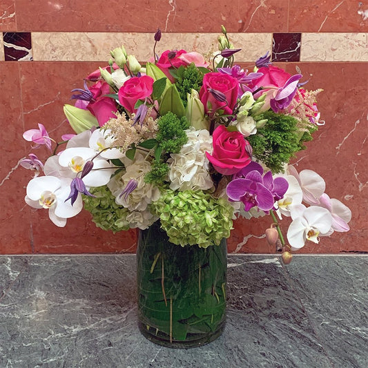 Cascade of color, stunning floral arrangement by Heather Floral, featuring roses, orchids and lilies