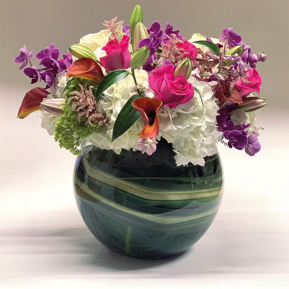 Cheerful Medley floral arrangement by Heather Floral, featuring brightly colored roses, orchids, amaryllis, and hydrangea